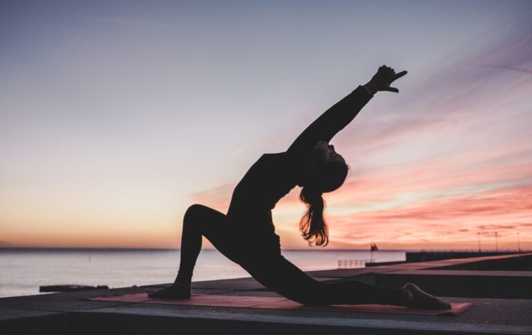 woman doing yoga at sunset