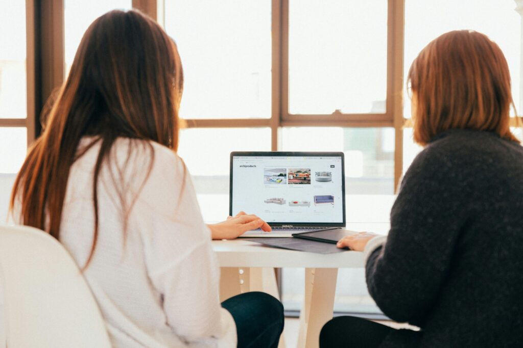 two women conducting research on a computer 